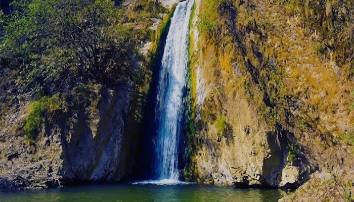 Jharipani Falls near Mussoorie with a tall waterfall cascading down rocky cliffs into a clear pool