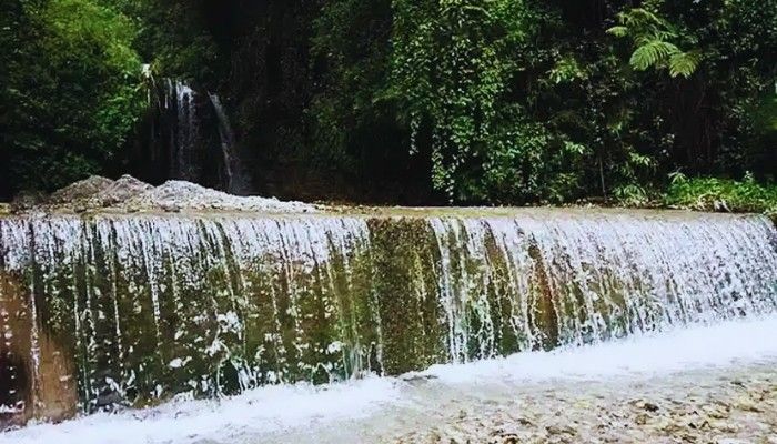 Mossy Falls near Mussoorie with water cascading over a natural stone ledge surrounded by greenery