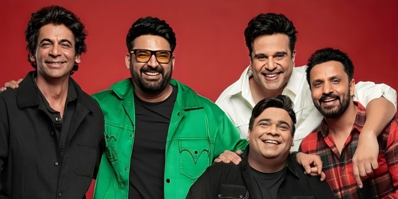 Group of male comedians smiling together in a studio photoshoot with a red background.