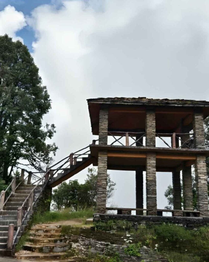 View from Zero Point in Almora showing pine trees, distant Himalayan hills, and open sky.